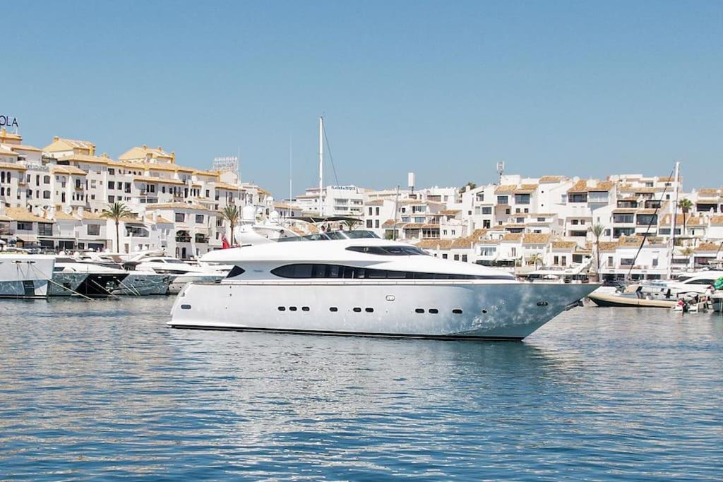 Superyacht docked in Puerto Banús Marbella harbour with luxury apartments in background