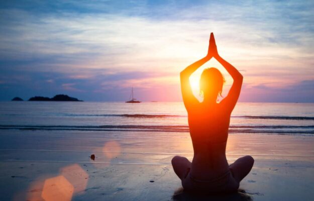 Group beach yoga session at sunrise in San Pedro, Marbella