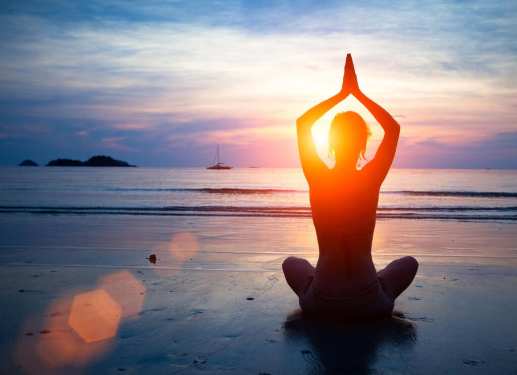 Group beach yoga session at sunrise in San Pedro, Marbella